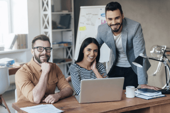 Berufswelt Erfahrungen Eine Gruppe junger Leute an einem Schreibtisch.