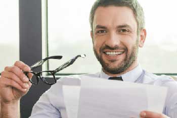 Produktmanager Produktmanager nimmt sich die Brille von der Nase und lächelt in die Kamera