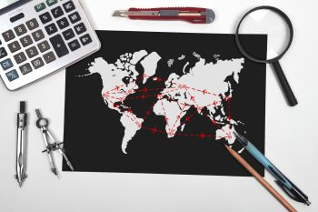 Auslandsstudium: Weltkarte liegt mit diversen Utensilien auf einem Tisch