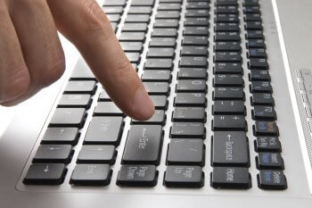 Tastatur in Nahaufnahme mit einem Finger, der auf Taste drückt
